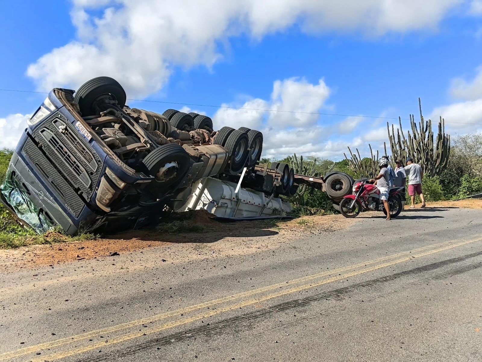 Caminhão carregado de milho tomba após motorista perder controle em curva